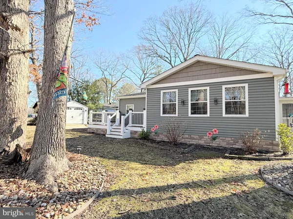 a front view of a house with a yard covered with snow