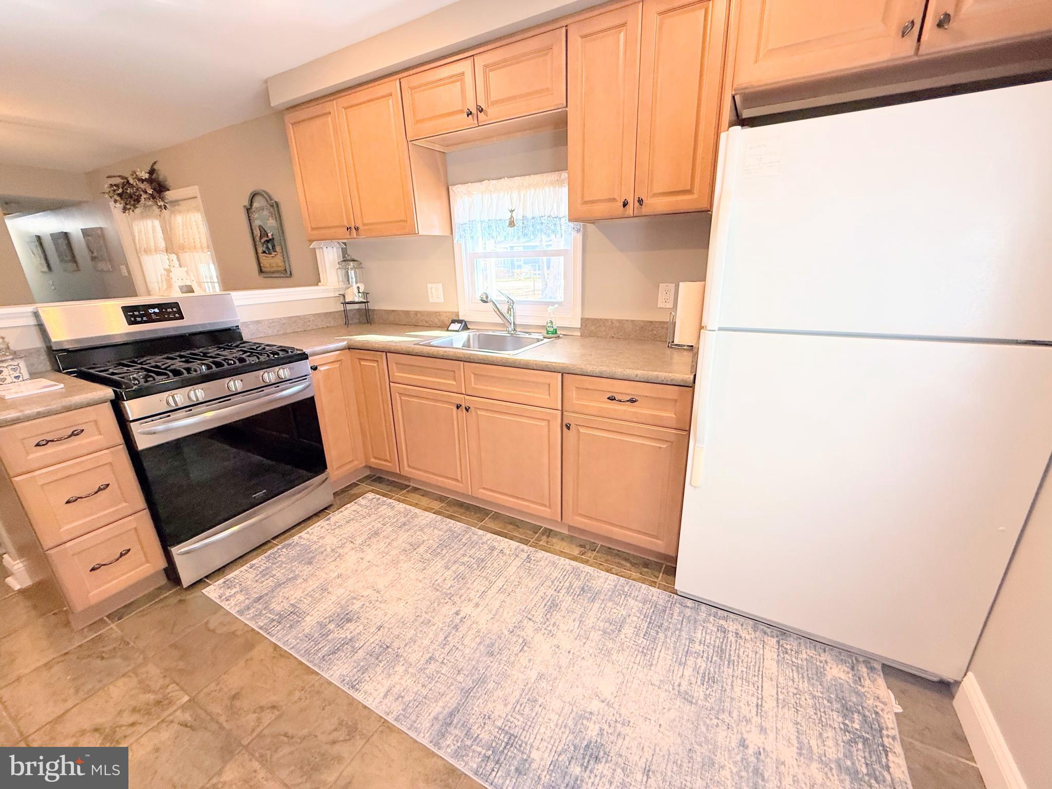 34479 Broad Water Road, Unit 644 Millsboro, DE 19966 - Photo 34 of 61 a kitchen with stainless steel appliances granite countertop a stove a sink and a refrigerator