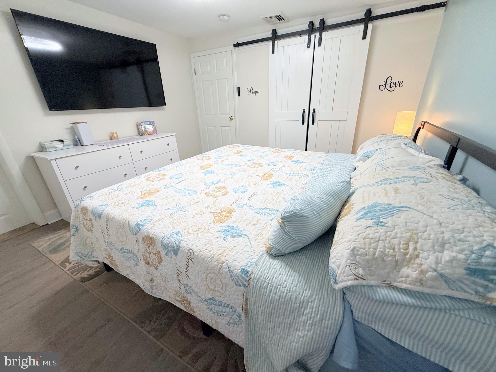 34479 Broad Water Road, Unit 644 Millsboro, DE 19966 - Photo 45 of 61 a bedroom with a bed a flat screen tv and a a couch