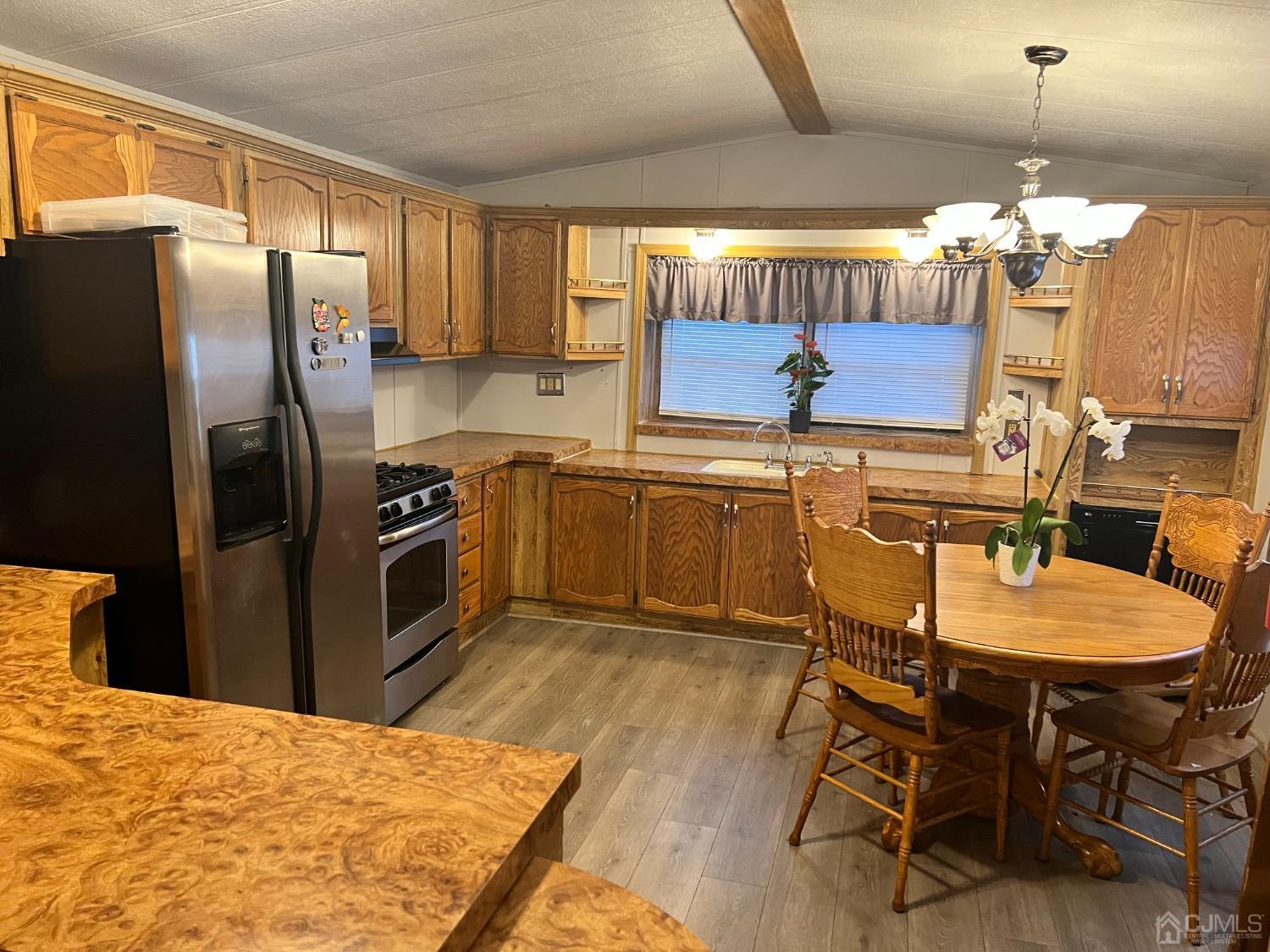33 Poe Road North Brunswick, NJ 08902 - Photo 6 of 13 a kitchen with stainless steel appliances kitchen island granite countertop a table chairs and a refrigerator