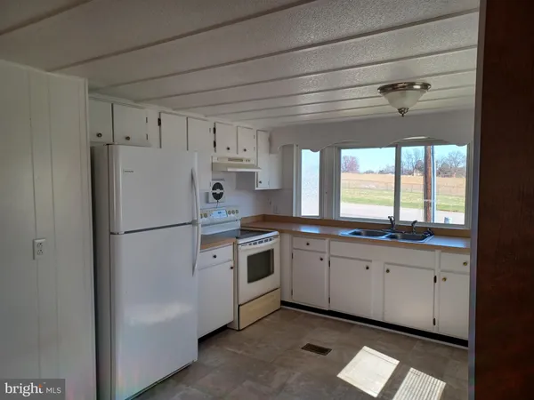 a kitchen with white cabinets and white appliances