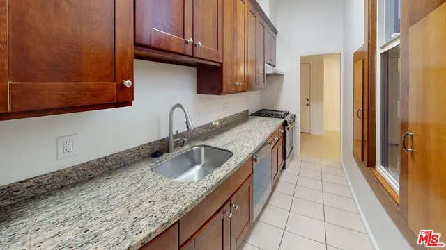 a kitchen with granite countertop a sink a stove and cabinets
