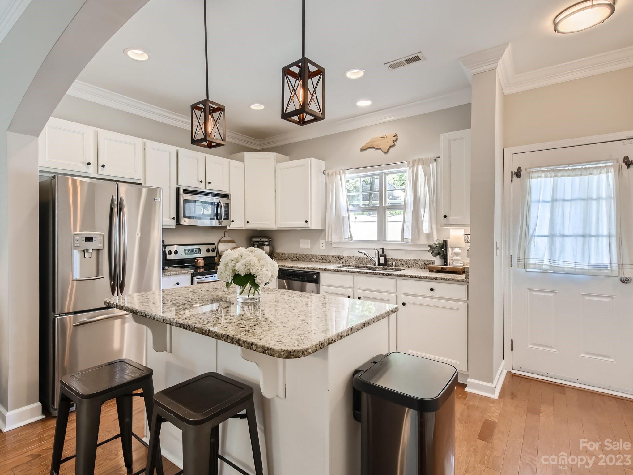 831 Millbrook Road Charlotte, NC 28211 - Photo 4 of 33 a kitchen with stainless steel appliances granite countertop a sink a stove a refrigerator cabinets and a dining table