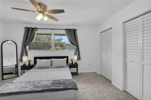 a bedroom with a bed and a large window