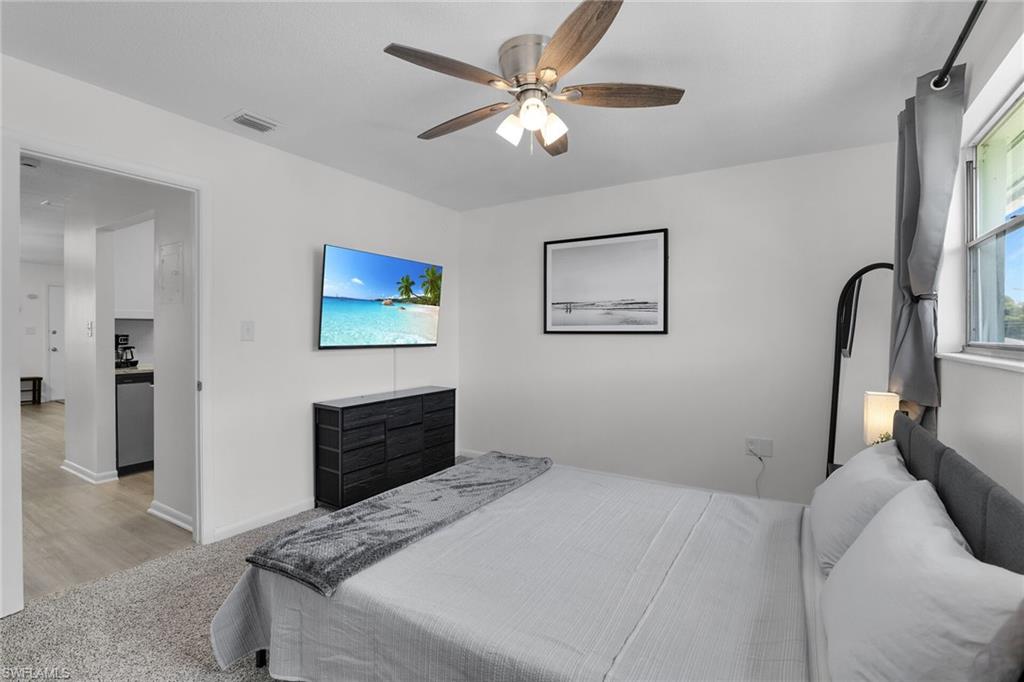 3225 East Riverside Drive Fort Myers, FL 33916 - Photo 12 of 33 a bedroom with a bed and a chandelier