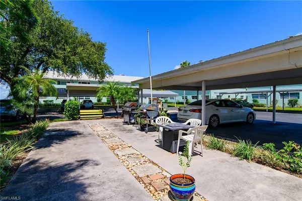 a view of a chairs and table in patio with a barbeque grill
