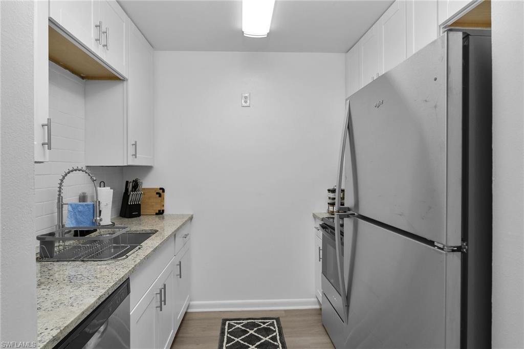 3225 East Riverside Drive Fort Myers, FL 33916 - Photo 7 of 33 a kitchen with a granite countertop sink and refrigerator