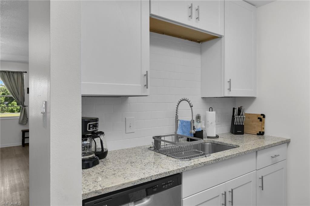 3225 East Riverside Drive Fort Myers, FL 33916 - Photo 8 of 33 a kitchen with granite countertop a sink a stove and cabinets