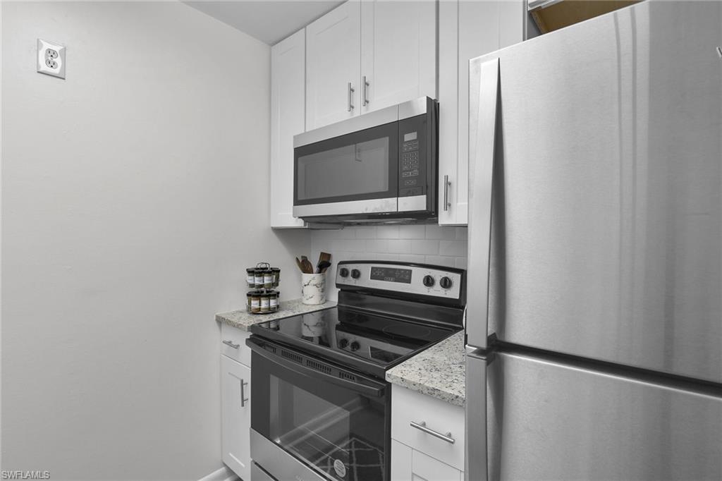 3225 East Riverside Drive Fort Myers, FL 33916 - Photo 9 of 33 a kitchen with granite countertop cabinets and steel stainless steel appliances