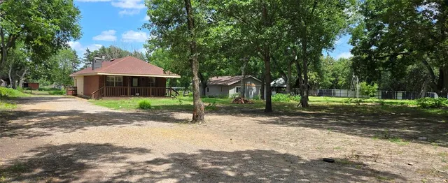 a front view of a house with a yard and tree
