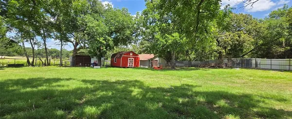 a view of a backyard with large trees