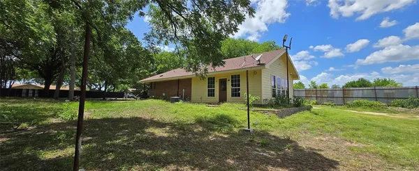 a view of a house with backyard and a tree
