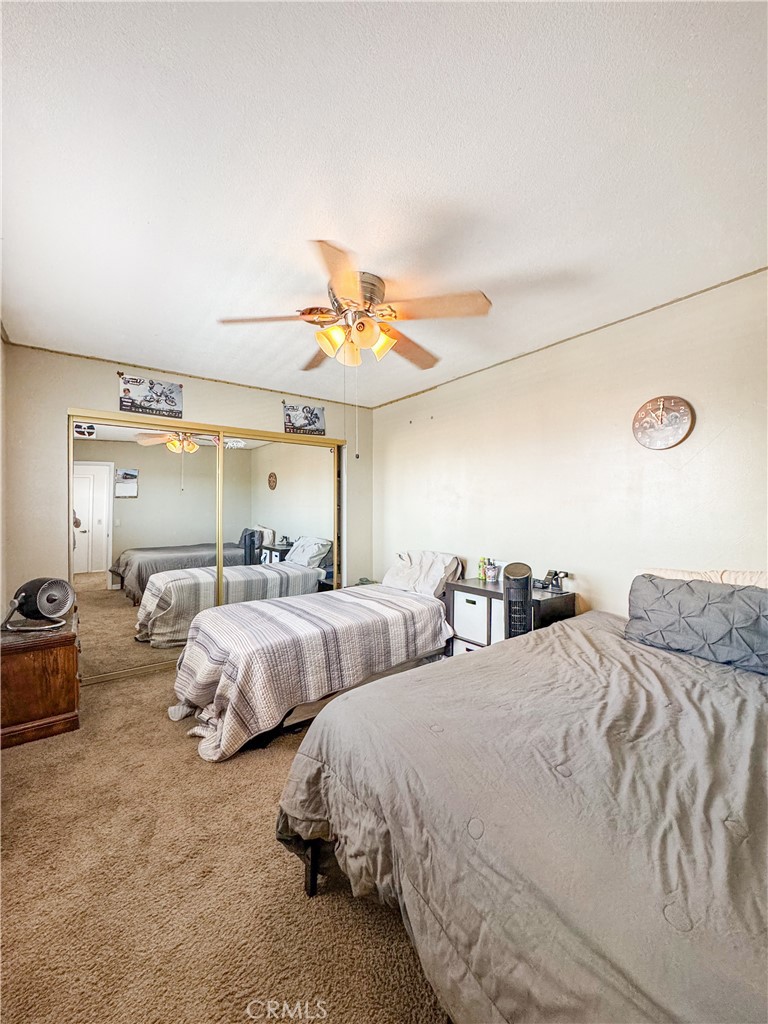 741 Ocotillo Road Blythe, CA 92225 - Photo 17 of 19 a spacious bedroom with two bed and a chandelier