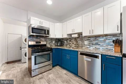 a kitchen with stainless steel appliances granite countertop a sink stove microwave and refrigerator