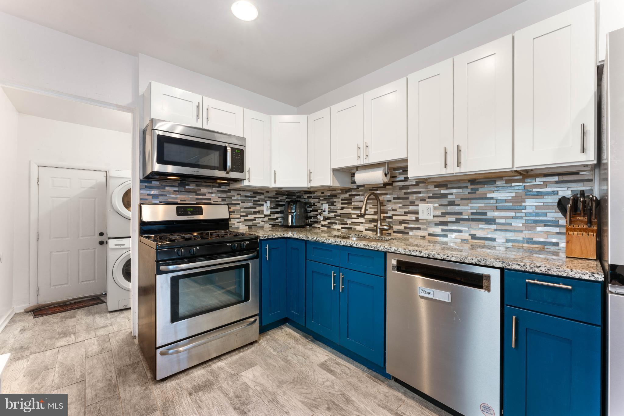 4618 Smick Street Philadelphia, PA 19127 - Photo 11 of 32 a kitchen with stainless steel appliances granite countertop a sink stove microwave and refrigerator