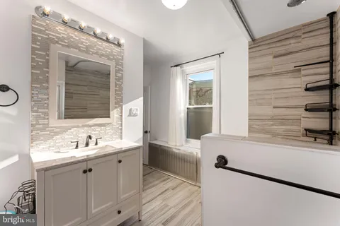 a bathroom with a sink mirror and a bathtub