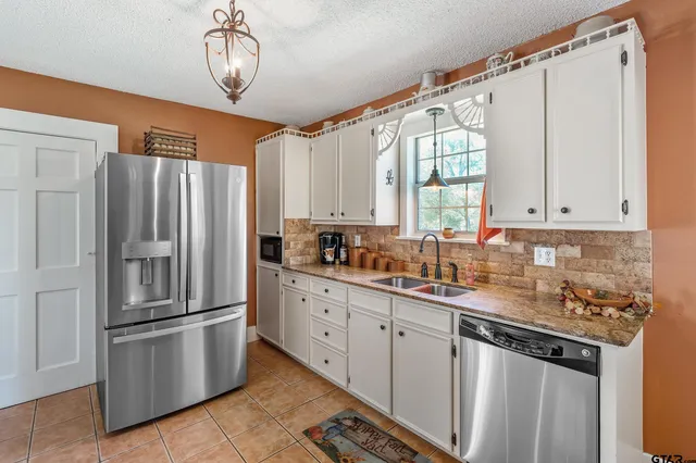 a kitchen with stainless steel appliances a refrigerator sink and cabinets