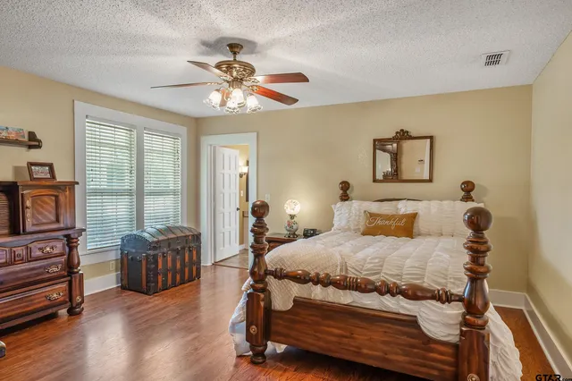 a bedroom with a bed and wooden floor