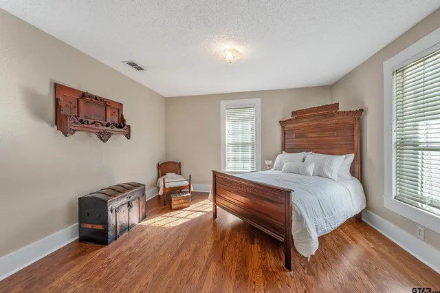 a bedroom with a bed and a dresser next to a window