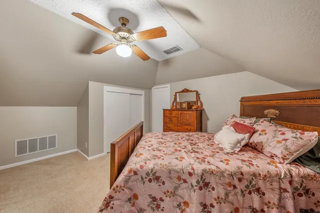 a bedroom with a large bed and a chandelier