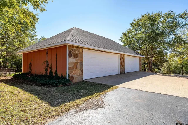 a front view of house with yard and trees in the background