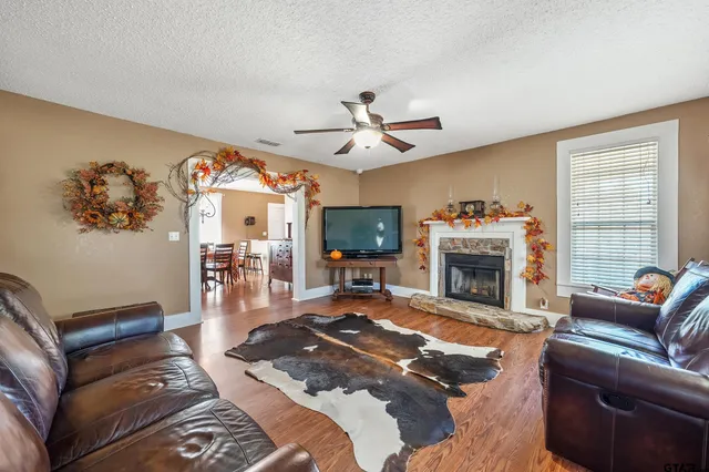 a living room with furniture a flat screen tv and a fireplace