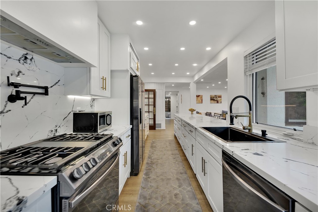 6409 Graves Avenue Lake Balboa, CA 91406 - Photo 16 of 50 a large kitchen with stainless steel appliances granite countertop a stove and a sink