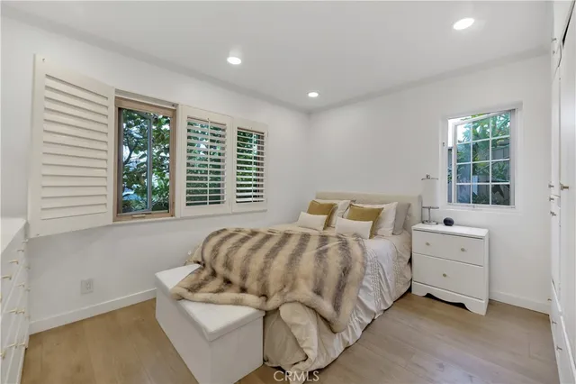 a bedroom with a bed and windows