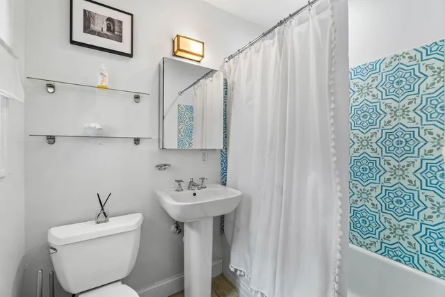 a bathroom with a sink and mirror with toilet