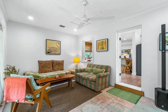 a living room with furniture and a baby crib