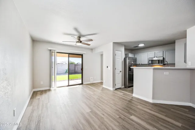 a view of a kitchen with a fridge wooden floor and a window