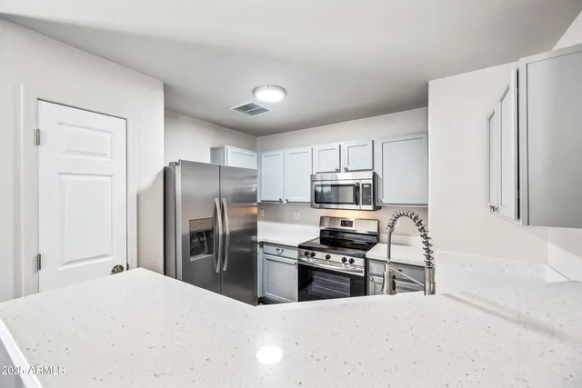 a kitchen with stainless steel appliances a refrigerator stove microwave and sink