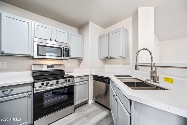 a kitchen with stainless steel appliances granite countertop a sink stove a microwave and cabinets