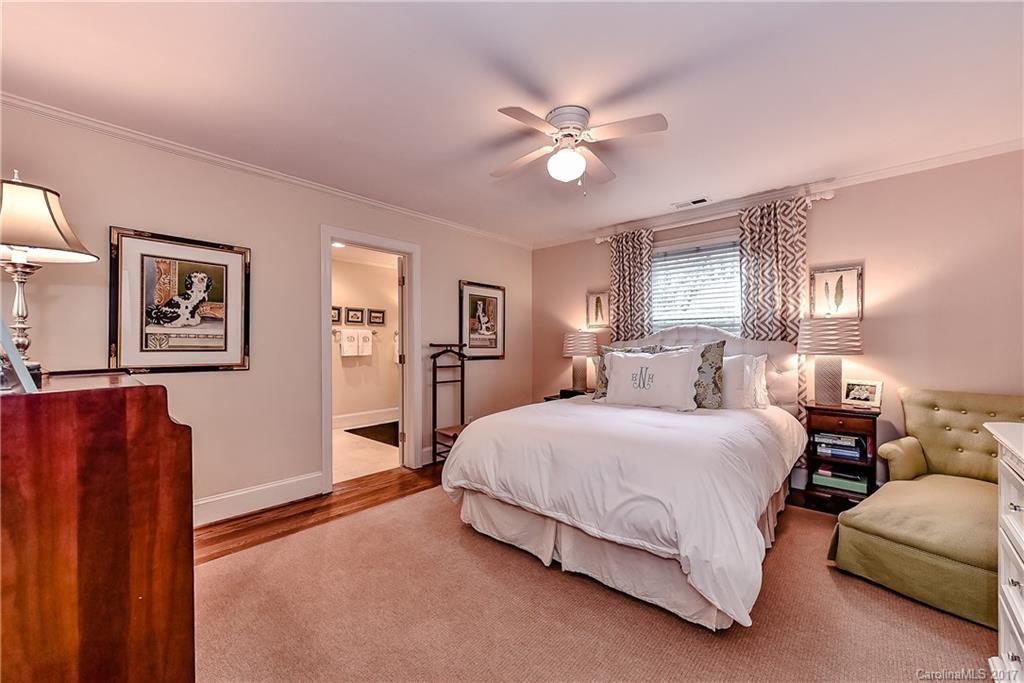 1028 Sedgefield Road Charlotte, NC 28209 - Photo 16 of 24 a bedroom with a large bed and a chandelier
