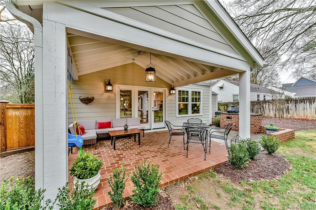 1028 Sedgefield Road Charlotte, NC 28209 - Photo 21 of 24 a view of a patio with table and chairs potted plants and floor to ceiling window
