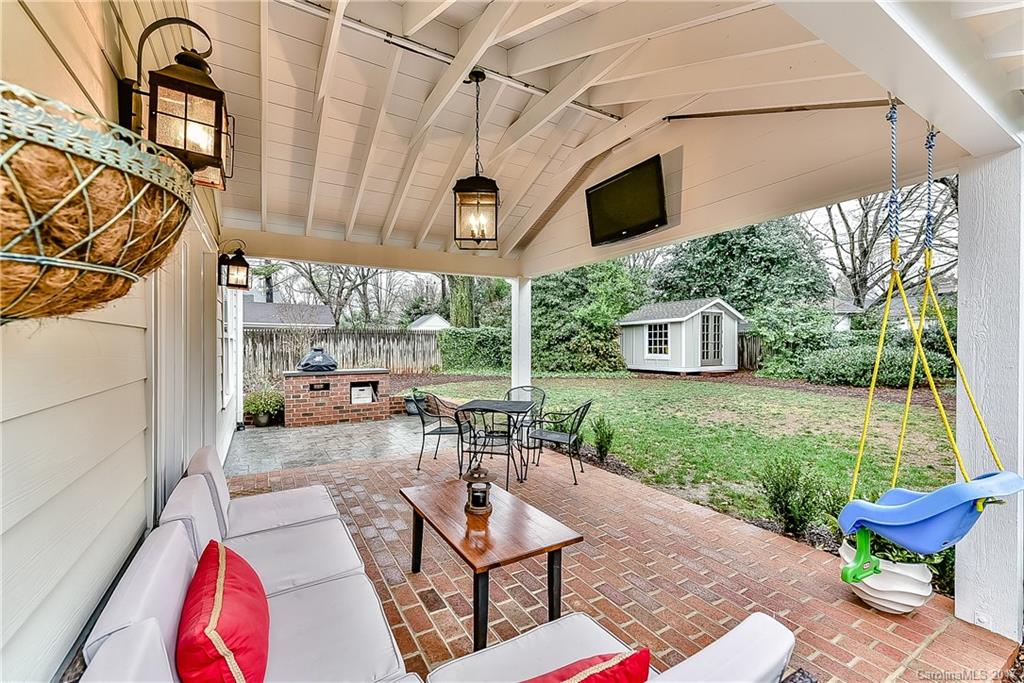 1028 Sedgefield Road Charlotte, NC 28209 - Photo 22 of 24 a view of a patio with table and chairs potted plants with wooden floor and fence