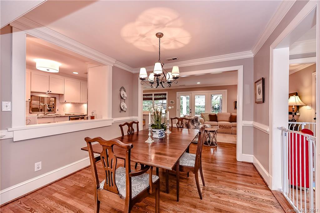1028 Sedgefield Road Charlotte, NC 28209 - Photo 4 of 24 a view of a dining room and livingroom with furniture wooden floor a chandelier