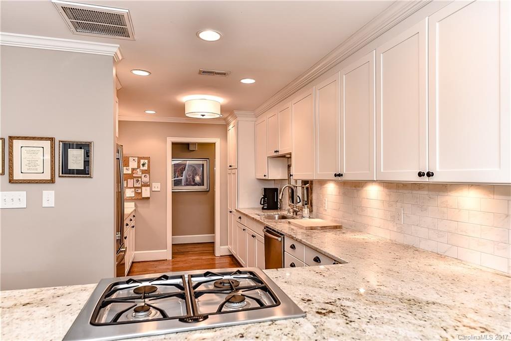 1028 Sedgefield Road Charlotte, NC 28209 - Photo 7 of 24 a kitchen with kitchen island granite countertop a stove and white cabinets