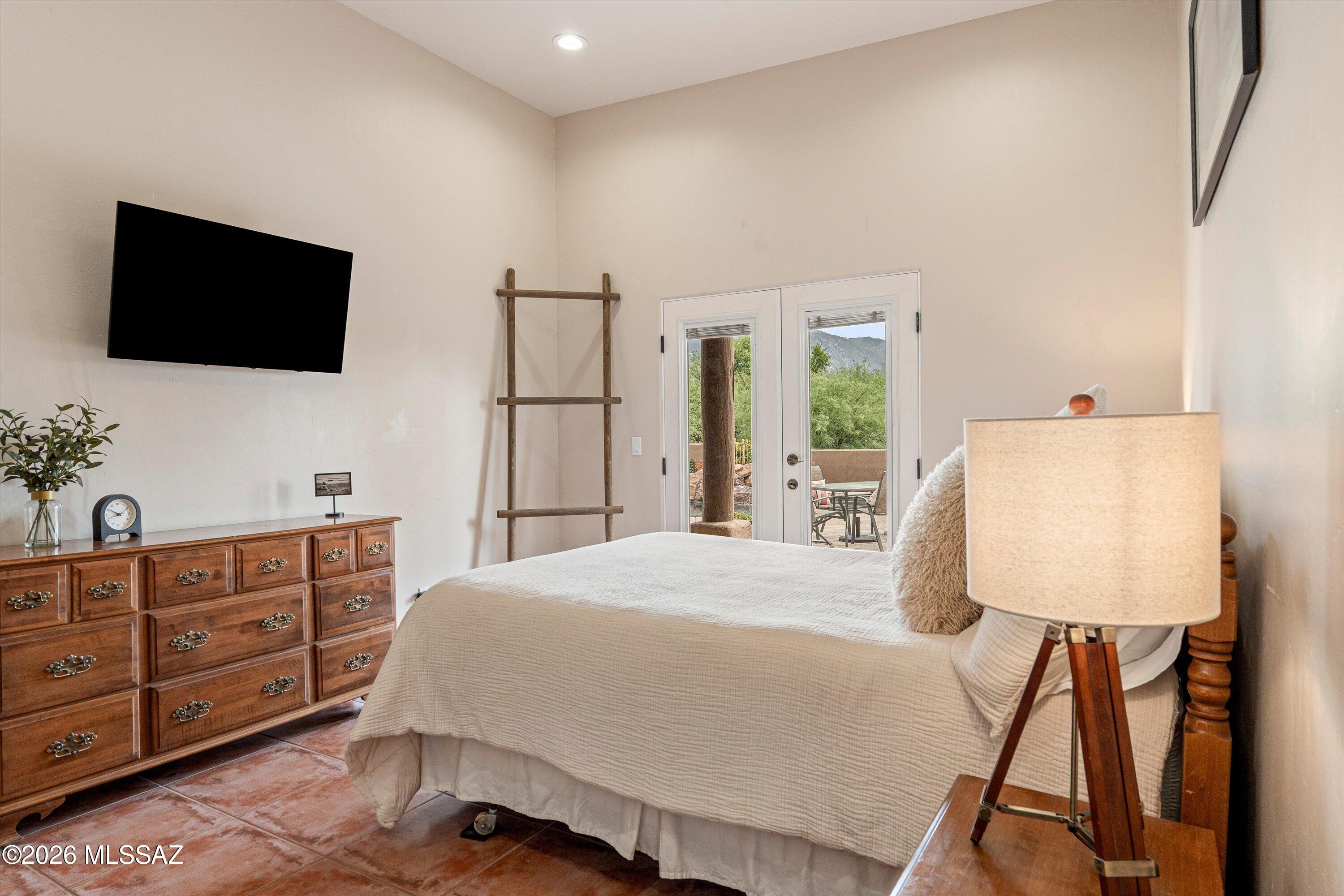 4760 East Wagon Train Road Tucson, AZ 85739 - Photo 15 of 38 a bedroom with a bed and a flat screen tv