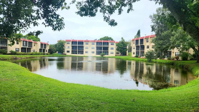 a view of a house next to a lake with a large trees