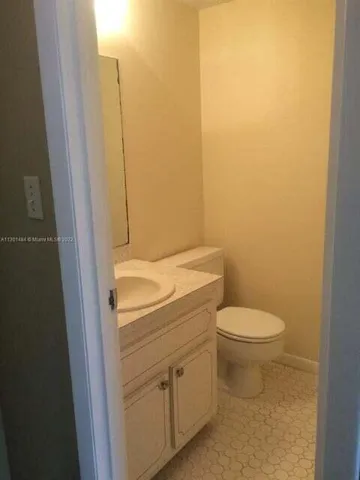 a bathroom with a granite countertop toilet and a sink