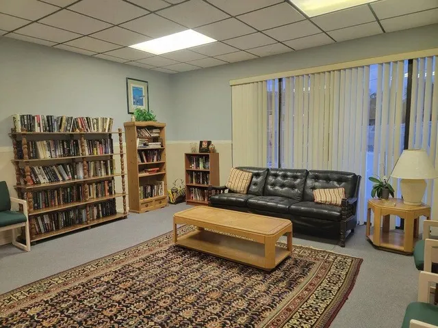 a living room with furniture and a book shelf