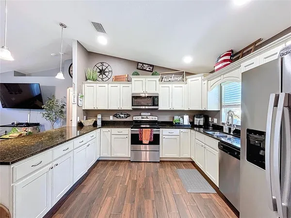a kitchen with stainless steel appliances granite countertop a stove and cabinets