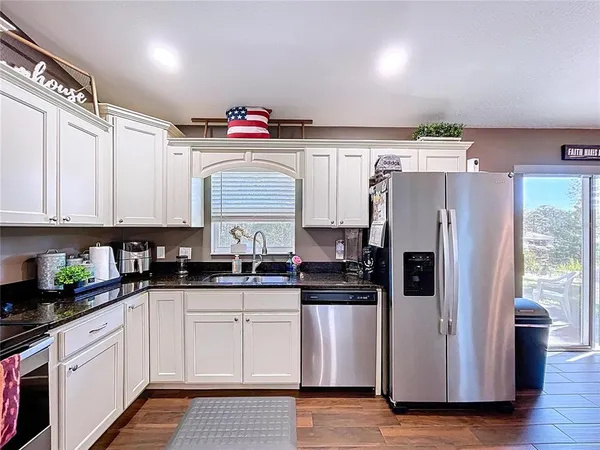 a kitchen with stainless steel appliances granite countertop a sink and cabinets