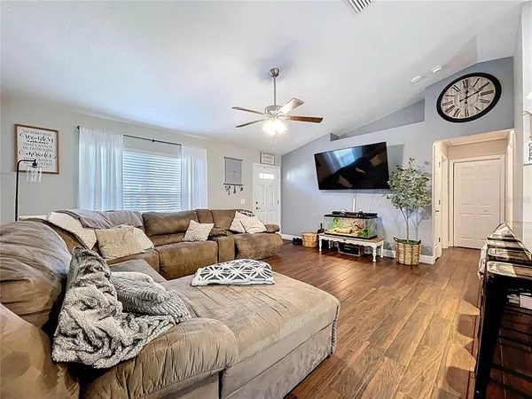 a living room with furniture and a wooden floor