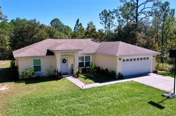 a view of a house with pool and sitting area
