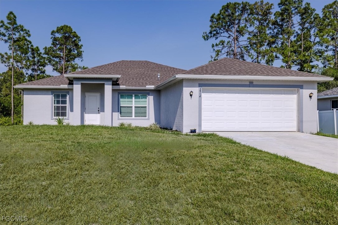 2914 Flora Avenue North Lehigh Acres, FL 33971 - Photo 1 of 39 a front view of a house with a yard and garage