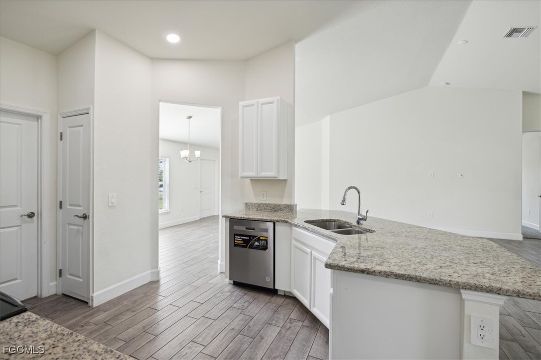 2914 Flora Avenue North Lehigh Acres, FL 33971 - Photo 11 of 39 a kitchen with stainless steel appliances granite countertop a sink and a refrigerator