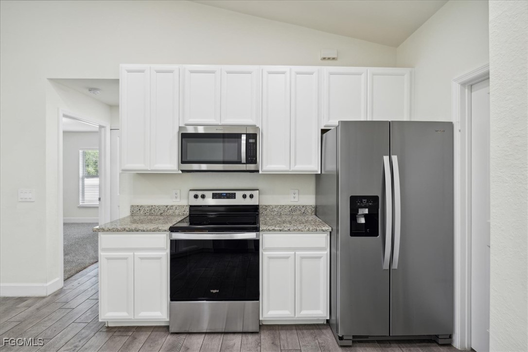 2914 Flora Avenue North Lehigh Acres, FL 33971 - Photo 12 of 39 a kitchen with a refrigerator stove and microwave