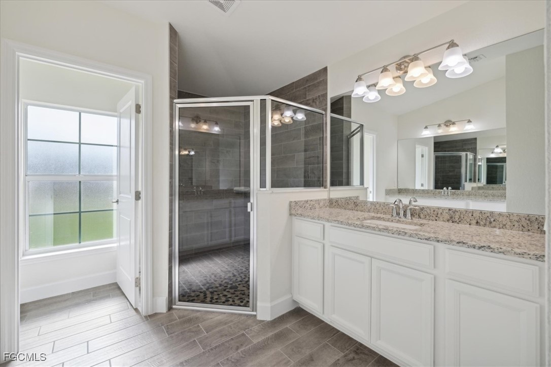 2914 Flora Avenue North Lehigh Acres, FL 33971 - Photo 17 of 39 a bathroom with a granite countertop sink mirror and shower